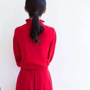 A girl seen from behind, dressed in red.